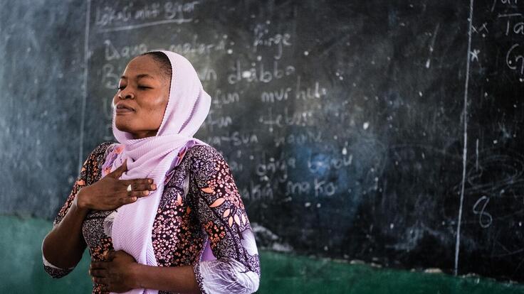 A teacher in Nigeria demonstrates mindfulness breathing techniques to students